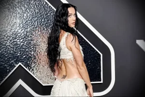 Фотография Doja Cat с маленьким черным QR-кодом татуировкой на пояснице, демонстрирующая современный подход к татуировкам.