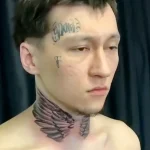 Фото тату: небольшие крылья на шее, выполненные в графическом стиле. Дополнены татуировками на лице, создавая яркий образ.