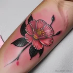 Цветная татуировка, изображающая цветущую георгину с яркими розовыми лепестками и детально проработанными листьями, выполненная в стиле Old School.