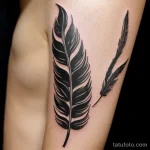 feather tattoo on a woman’s upper arm, black ink, close-up, tatufoto.com 302