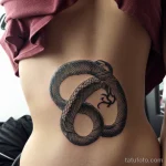 snake tattoo on a woman’s ribcage, black ink, detailed, tatufoto.com 317