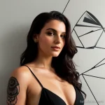 stylish woman with a triangle tattoo on her wrist, symbolizing balance, posing confidently against a modern art wall tattoo lion tatufoto.com 158