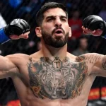 Фото тату на груди бойца MMA с изображением тигра и волка, выполненное в реалистичном стиле с использованием темных оттенков серого и черного.