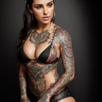 Фото тату: девушка с яркими и детализированными татуировками в стиле ориентал на руках, груди и животе. Идеи для тату.