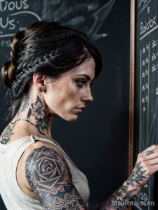 Фото девушки с татуировками в стиле blackwork на шее, плече и руке. Изящные растительные мотивы и геометрические узоры.