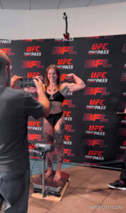 Фотография девушки-бойца MMA на взвешивании перед боем. На ее теле видны татуировки.