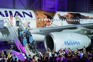 Фотография самолета Hawaiian Airlines, украшенного ярким дизайном персонажей диснеевского мультфильма Moana. Видны изображения Моаны, Мауи и других героев.
