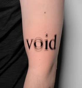 Фото татуировки с надписью 'void' на руке мужчины. Черная надпись выполнена простым шрифтом и расположена на предплечье.