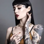 Фотография девушки с татуировками на лице, шее и руках, демонстрирующая смелый и стильный боди-арт. Идеально для поиска идей для татуировок.