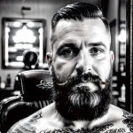 Как вес влияет на тату A middle-aged man with a faded traditional eagle tattoo on his chest sitting in a barbers chair vintage barbershop interior tatufoto.com 188