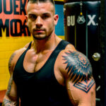 Как вес влияет на тату A muscular man with a phoenix tattoo on his arm standing in a gym tank top drenched in sweat bold black-and-red ink design b tatufoto.com 133