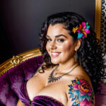 Как вес влияет на тату A plus-size woman with a colorful chest tattoo lounging on a velvet armchair wearing a strapless dress dark curly hair pinned tatufoto.com 031