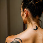 Как вес влияет на тату A slender woman with a minimalist moon tattoo on her neck standing in a dimly lit room wearing a high ponytail tattoo blendin tatufoto.com 159