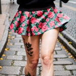 Как вес влияет на тату A tall woman with a full leg floral tattoo wearing a short skirt standing on a cobblestone street medium-length platinum hair tatufoto.com 146