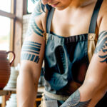 Как вес влияет на тату A woman with a minimalist finger tattoo working at a pottery wheel wearing an apron short cropped black hair subtle linear t tatufoto.com 174