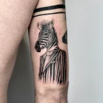 Фото тату зебры, одетой в костюм и галстук. Черно-белый рисунок татуировки с реалистичной проработкой деталей.
