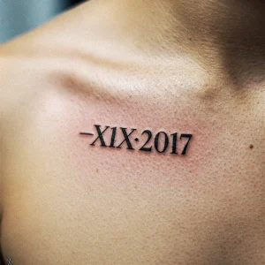 Фото тату с римскими цифрами '-XIX-2017' на коже. Черные чернила, простой и лаконичный дизайн.