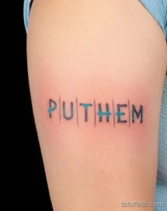 Фото тату надписи 'PUT THEM' на руке, выполненной в стиле неоновой графики. Яркий рисунок с использованием голубых и синих оттенков. Современный и стильный дизайн.