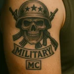 Фото тату с изображением черепа в каске, перекрещенного оружия и надписи 'MILITARY MC'. Черно-серая татуировка на плече, символизирующая военную службу и принадлежность к сообществу.