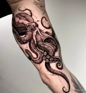 Фото тату: стилизованный осьминог, выполненный в технике blackwork, на руке. Детализированные щупальца и выразительные глаза.