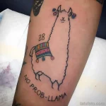 Фото тату: стилизованная альпака с забавной надписью 'No Prob-Llama', украшенная цветами. Расположена на предплечье.