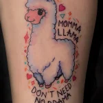 Фото тату милой ламы с надписью "Momma Llama Don't Need No Drama". Яркий рисунок татуировки на руке с пастельными тонами.