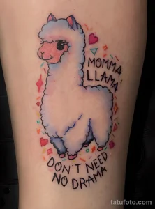Фото тату милой ламы с надписью "Momma Llama Don't Need No Drama". Яркий рисунок татуировки на руке с пастельными тонами.