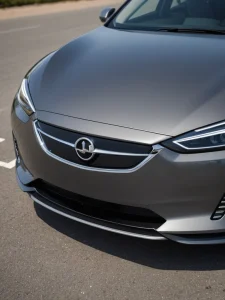 Фотография передней части серого автомобиля Opel с хромированной решеткой радиатора и логотипом. Современный дизайн и четкие линии.