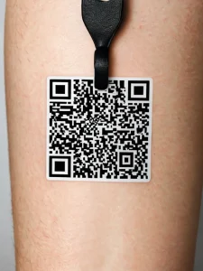 Фото тату QR-кода на ноге. Черно-белый рисунок, имитирующий настоящий QR-код, нанесен на кожу.