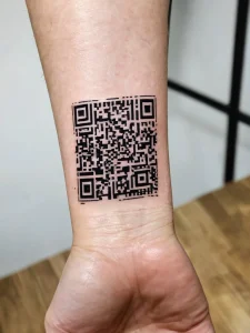 Фото тату минималистичного QR-кода на запястье. Черный квадратный рисунок, который можно отсканировать смартфоном. Современный и необычный дизайн.