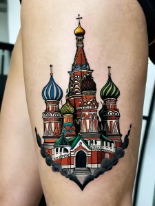 Фото татуировки на бедре, изображающей собор Василия Блаженного в Москве. Яркие цвета и детализированная проработка.