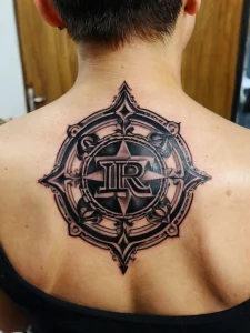 Фото тату в стиле Blackwork с геометрическим узором и буквами 'IR' на спине. Детализированный рисунок.