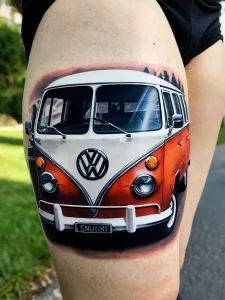 Фото тату: красочный рисунок Volkswagen Bus на бедре с закатным небом и детальной проработкой.