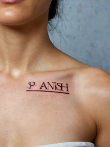Фото тату на груди: простая черная надпись "PANISH" под линией, выполненная в минималистичном стиле.