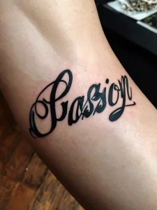 Фото тату на запястье с надписью "Passion", выполненной в красивом каллиграфическом стиле. Черный рисунок татуировки выглядит элегантно и выразительно.