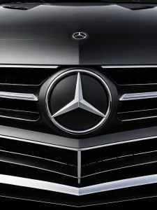 Макро-съемка татуировки, сочетающей логотип Mercedes-Benz с символом пацифики, подчеркивающая контраст между брендом роскоши и миром, фотореализм.