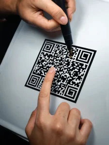 Фото процесса нанесения QR-код татуировки на кожу, с использованием тату-машинки.
