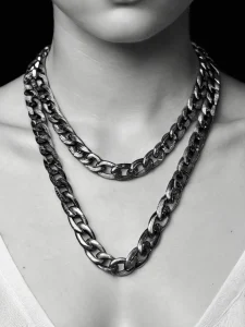 Фото тату: две массивные цепи, расположенные на шее, выполненные в стиле blackwork. Четкие линии, контрастный дизайн, минималистичный подход.
