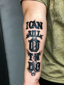 Фото тату на руке с надписью "I Can Do All Things Through Christ", украшенной морскими якорями и веревками.