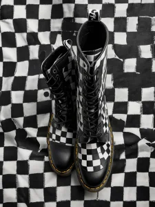 Фото тату: изображение ботинок Dr. Martens в черно-белую клетку, расположенное на фоне клетчатой поверхности.