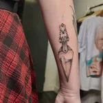 Фото тату в стиле дотворк: бутылка с тонкими линиями и точками, создающими эффект тени. Детализированный рисунок татуировки.