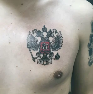 Фото татуировки двуглавого орла на груди мужчины. Черно-белый рисунок с детальной проработкой перьев и короны.
