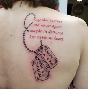 Фото тату на спине: два жетона с именами, соединенные четками, и надпись 'Together forever and never apart'. Черно-белая татуировка.