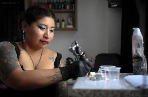 Daniela Artemisa, the 'Cholita Tattoo Artist', tattooing a client