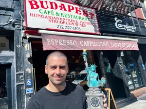 Misi Furucz, чемпион татуировки, с наградой на фоне кафе Budapest в Нью-Йорке