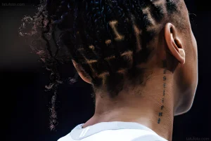Крупный план затылка и шеи баскетболистки Jewell Loyd с вертикальной татуировкой и сложной прической.