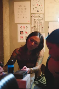 Тату-мастер работает над татуировкой на мероприятии CENSU Crew Tattoo Pop-Up в Golden Gip