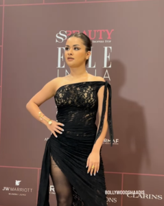Avneet Kaur на Elle Beauty Awards в черном платье, демонстрирующем татуировку на ноге.