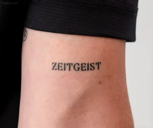 Минималистичная татуировка надписи 'ZEITGEIST' на лодыжке