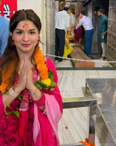 Avneet Kaur в традиционном индийском наряде с татуировкой на руке, сложив руки в молитвенном жесте.